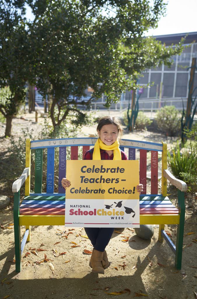 happy child holds sign celebrating teachers